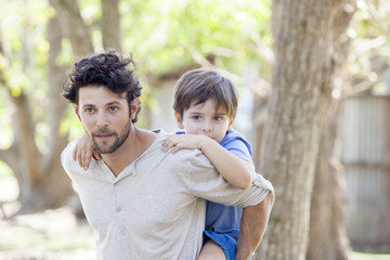 Father carrying young son piggyback