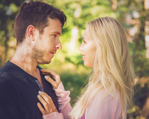 Young, happy woman flirting with a man in the park in the summer.