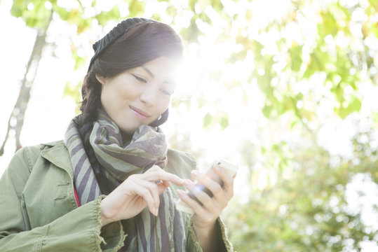 Young woman using smartphone outdoors