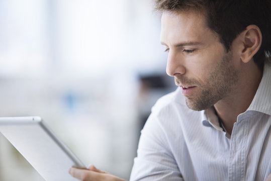 Mid-adult man using digital tablet