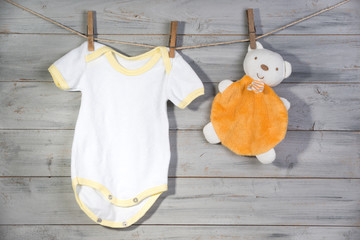 Baby clothes and bear toy on a clothesline