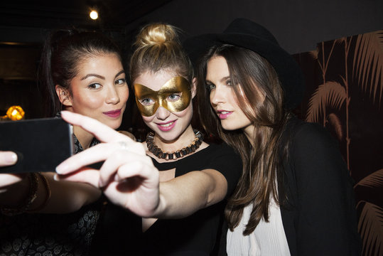 Young women at night club taking selfie