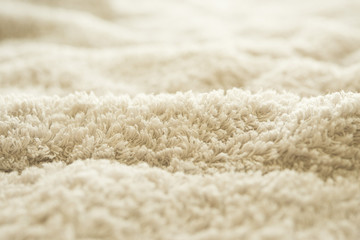 Fototapeta na wymiar хлопковое махровое полотенце текстура. бежевая махровая ткань складки размытый фон