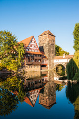 Fototapeta na wymiar Hangman's Tower (Henkerturm) and traditional medieval half-timbered (fachwerk) house over the river Pegnitz in Nuremberg, Germany