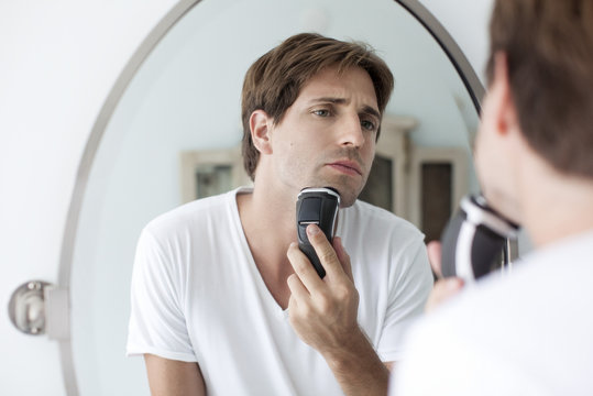 Man shaving with electric razor