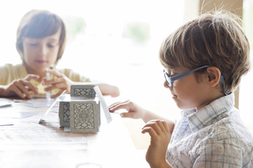 Boys building house of cards together