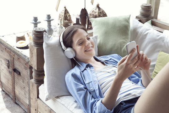 Young woman relaxing with smartphone and headphones