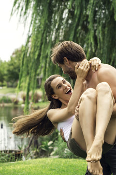 Young man playfully carrying girlriend