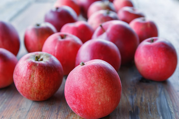 Red apples lie on a wooden table in the garden.Focus concept.
