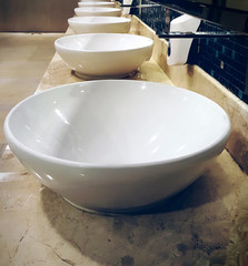 white basins in bathroom interior with granitic tiles