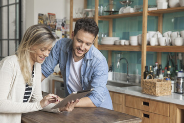 Couple using digital tablet in kitchen