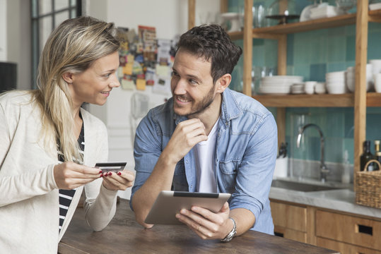 Couple using digital tablet to shop online at home