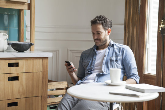 Man using smartphone at home