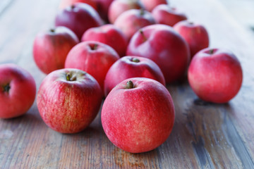 .Red apples lie on a wooden table in the garden.Focus concept.