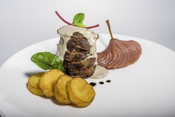 Grilled fillet mignon with baked potatoes and pear in red wine