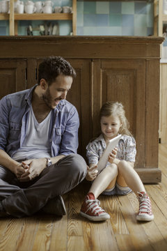 Girl showing father digital tablet