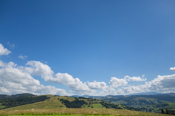 Fototapeta premium meadow, mountain and sky with clouds