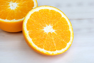 Half of orange on the wooden table.