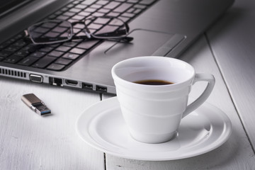 Laptop stick, glasses and a cup of coffee