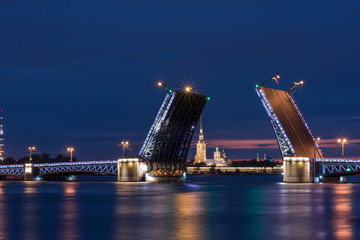 Fototapeta na wymiar White nights. View of Neva river and raised Palace Bridge in St.