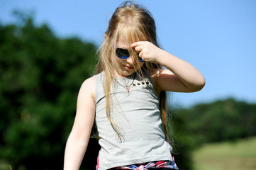 caucasian cute little girl in forest green field, summer