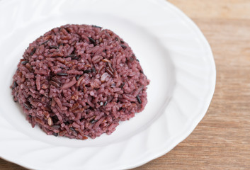 Cooked purple rice berry in plate on wooden