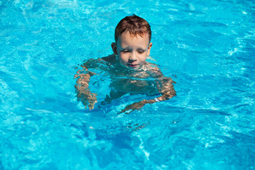 cute kid, boy swimming in pool water
