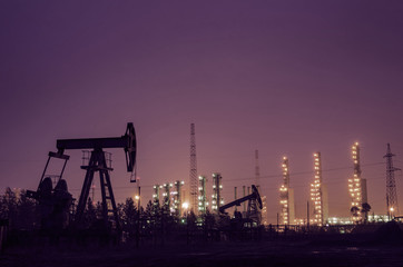 Oil rig at the background of refinery by night. Oil and gas industry. Toned. 