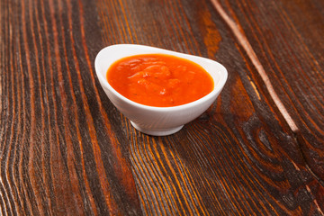 tomato sauce with a bowl on wooden table