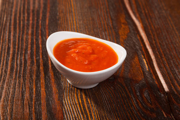 tomato sauce with a bowl on wooden table