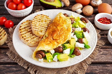 Mushroom, Feta Cheese egg Omelette witch Avocado, vegetables, lettuce, herbs and grilled bread.