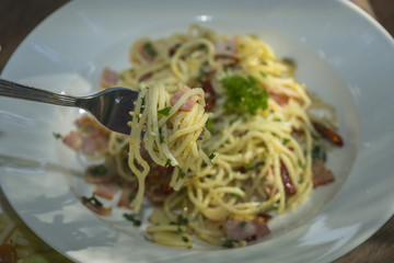 Spaghetti with bacon and dried chilli with a fork, pasta