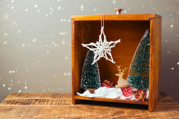 Christmas diorama with pine trees and decorations on wooden table
