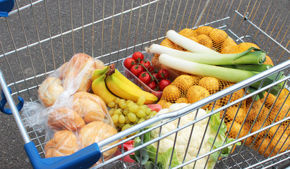 Einkaufswagen mit frischem Obst, Gemüse und Semmeln
