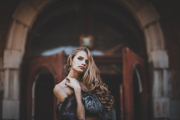 Obraz premium Young beautiful girl in vintage romantic antique dress near the vintage wooden door. fairy tale, legend