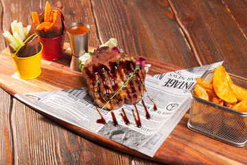 pork steak with French fries on a wooden cutting board