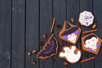 Dracula, witch, ghost, bat, spider in web. Halloween homemade gingerbread cookies on black wooden background.  Free place for text.