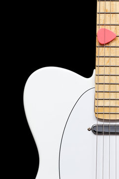 pink pick on white electric guitar, isolated on black