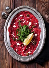 Beef carpaccio with capers, parmesan, arugula, lemon and olive oil.