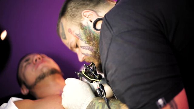 tattoo artist in the process of making a tattoo