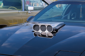 Close-up of an old car. Part of the exterior. An American classic. Chrome lining. Glass with reflection.