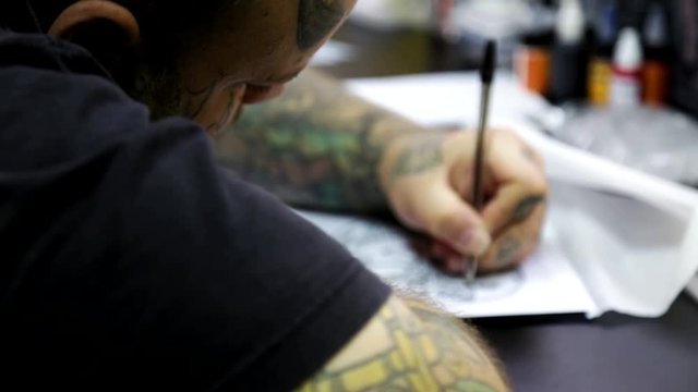 The artist prepares a sketch of the tattoo