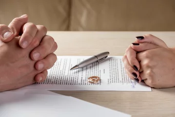 Ehefrau und Ehemann unterzeichnen Scheidungsdokumente oder voreheliche Vereinbarungen © krivinis