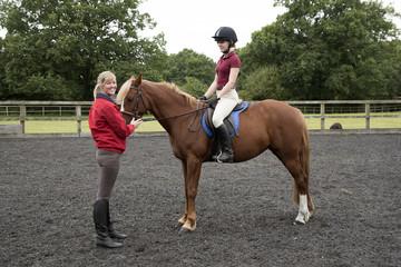 Young pony rider sitting in the saddle - September 2016 - Teenager learning to ride with the...