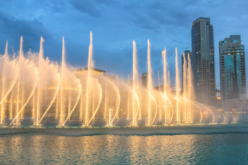 Naklejka premium Nocny widok pokazu świateł w tańczącej fontannie w Dubaju. Dubajska fontanna, największa na świecie fontanna z choreografią na obszarze jeziora Burj Khalifa, gra w rytm wybranej muzyki.