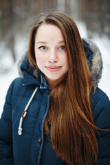 Beautiful woman in winter clothes standing in winter par