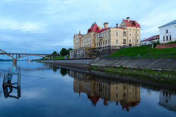 Former Grain Exchange on waterfront with reflection in water, Rybinsk, Russia