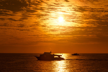 Statki na morzu podczas złocistego wschodu słońca 