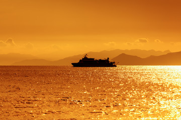 Statek na morzu podczas złocistego wschodu słońca 