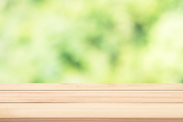 Smooth wood table with green blurry trees background, nature con